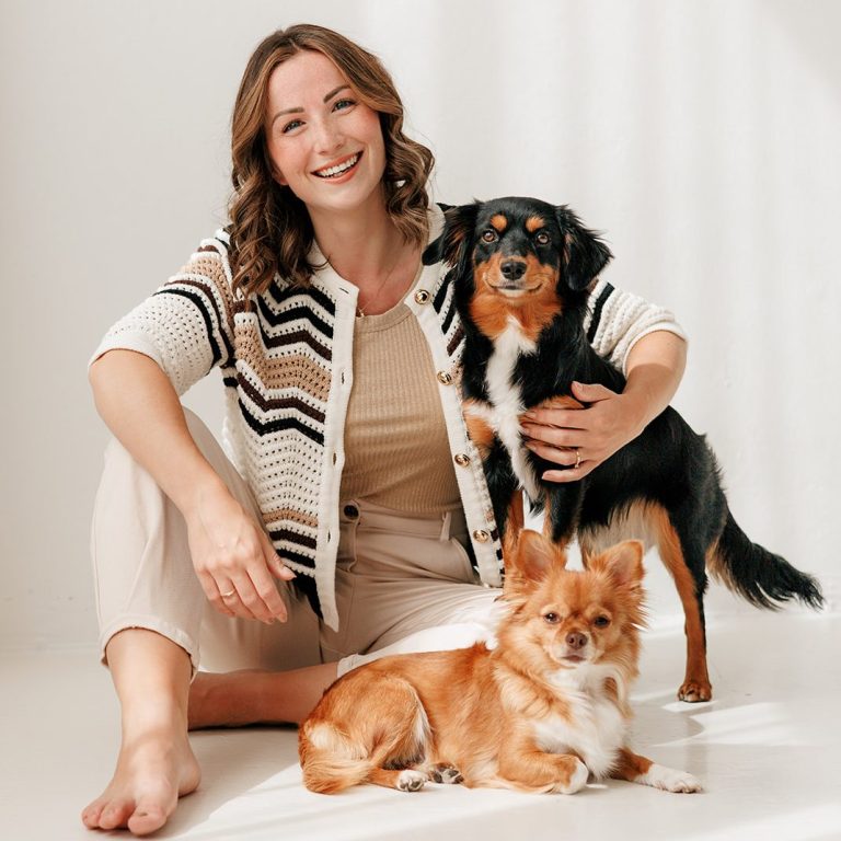 Authentisches Coaching zur Begleitung von Krankheit und Krisen Eine Frau sitzt mit einem schwarzen Hund und einem braunen Hund auf dem Boden.